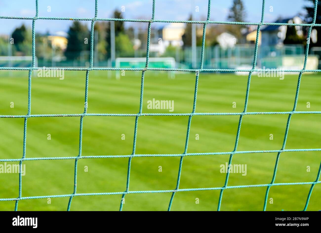 Blick durch die Vernetzungen eines Fußballtores auf den Spielplatz Stockfoto