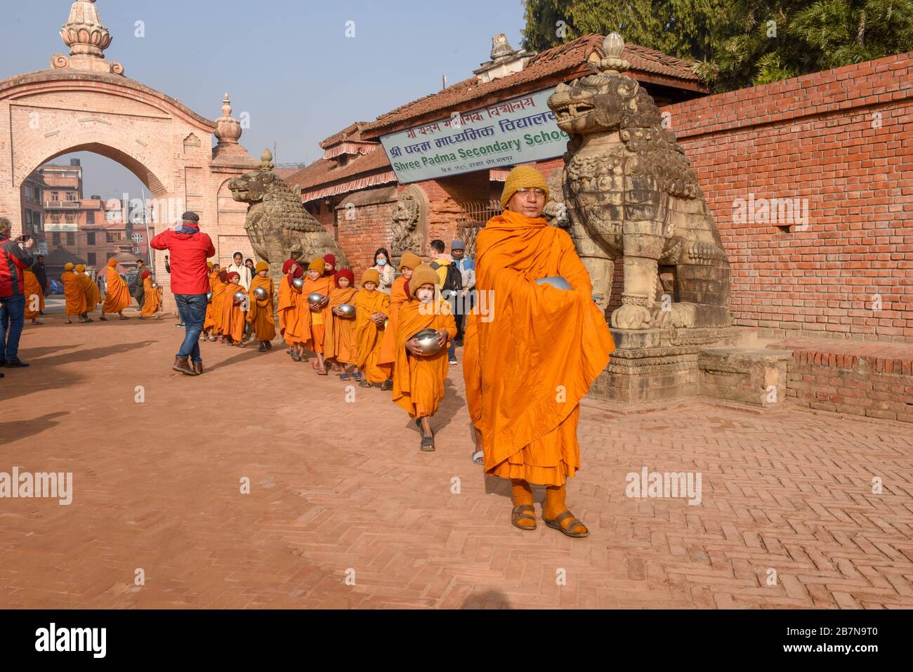 Bhaktapur, Nepal - 28. Januar 2020: Junge buddhistische Mönch, die in Morgenalmen in Bhaktapur auf Nepal spazieren gehen Stockfoto