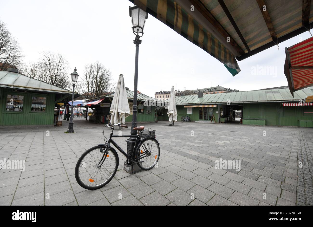 München, Deutschland. März 2020. Teile des Viktualienmarktes im Zentrum Münchens sind menschenleer. Um die Ausbreitung des Coronavirus zu verlangsamen, ist das öffentliche Leben in Bayern eingeschränkt. Ab dem 18.03.2020 müssen viele Geschäfte in Bayern geschlossen bleiben, Restaurants haben nur noch einen eingeschränkten Betrieb. Credit: Tobias Hase / dpa / Alamy Live News Stockfoto