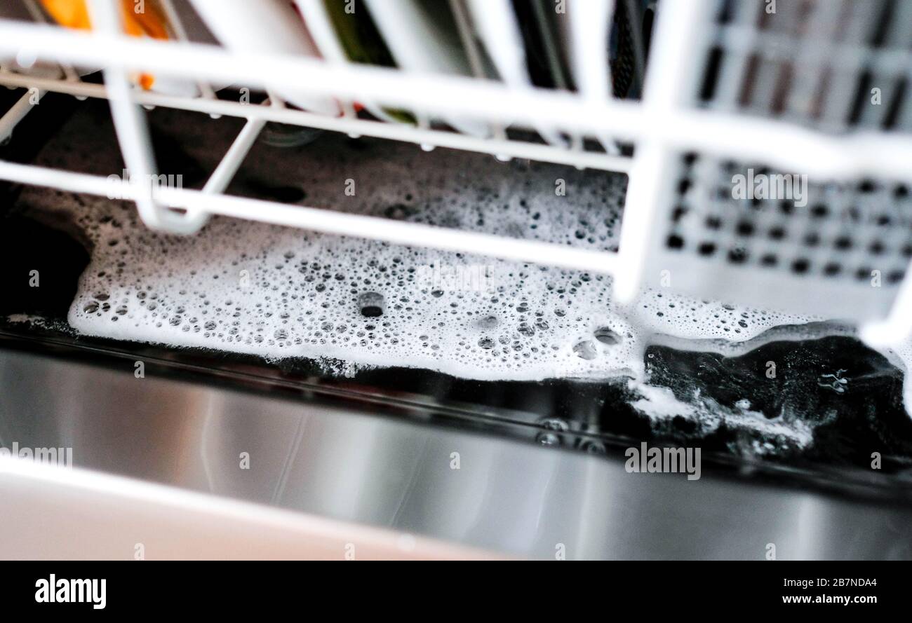 Überschüssiges Reinigungsmittel am Boden des Geschirrspülers nach dem Waschen. Schaum. Stockfoto