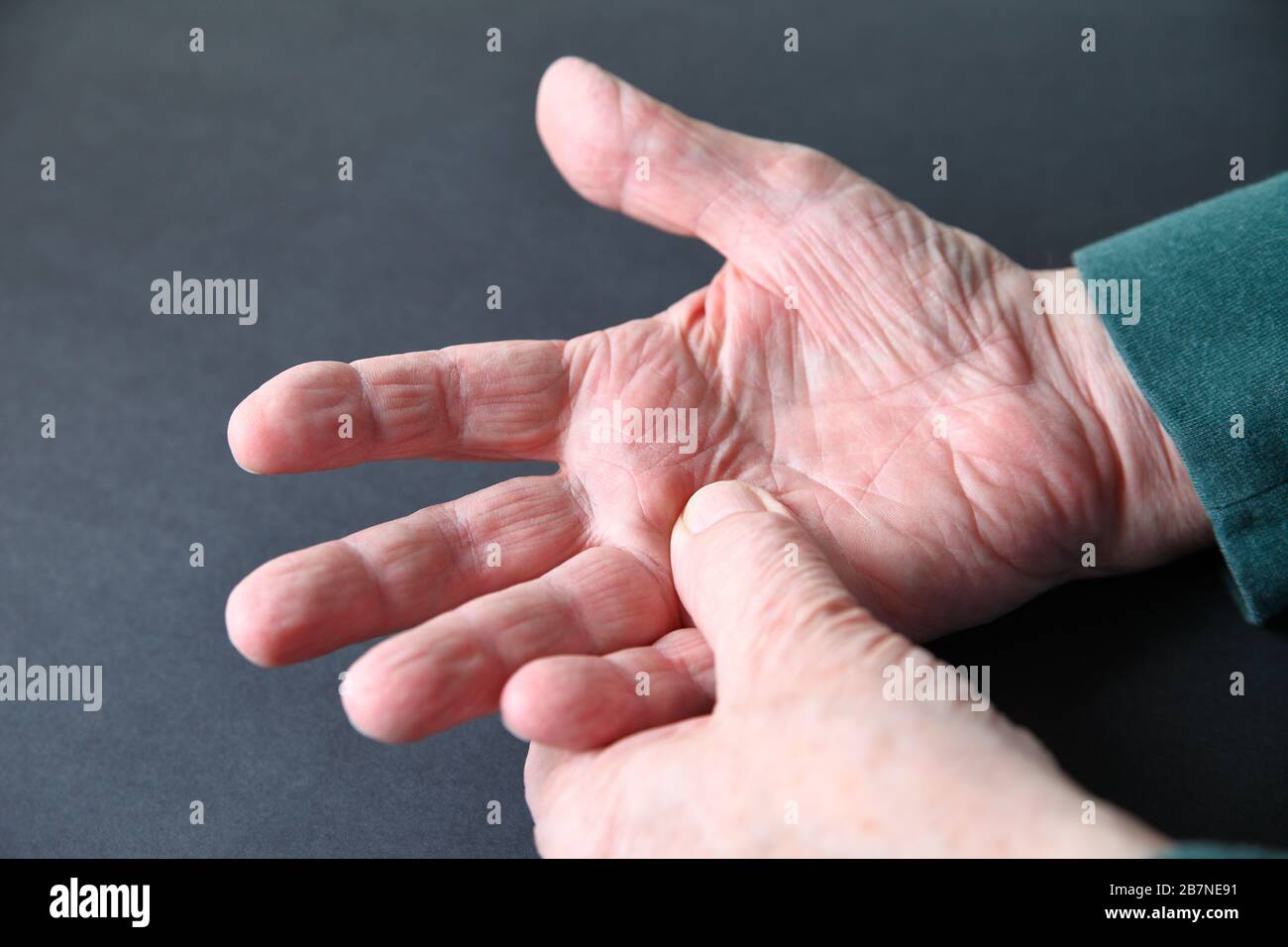 Senior Mann mit einer Wunde Hand auf dunkelgrauem Hintergrund Stockfoto