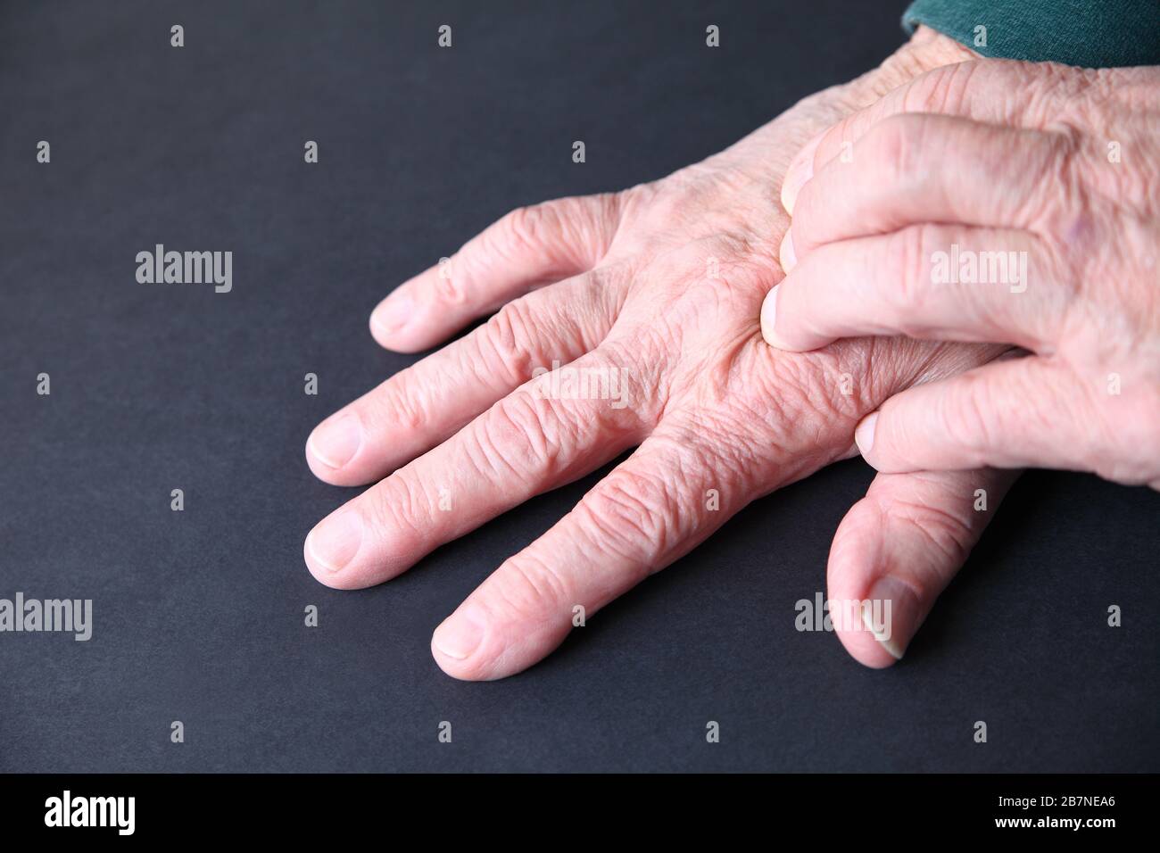 Der ältere Mann drückt seine Finger auf die Oberseite einer Hand Stockfoto