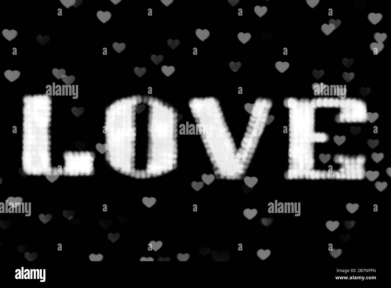 Verschwommener Text weißes LIEBESZEICHEN LED bokeh Neon hell weiß auf Hintergrund bokeh leuchtet Herz weich bunt Stockfoto