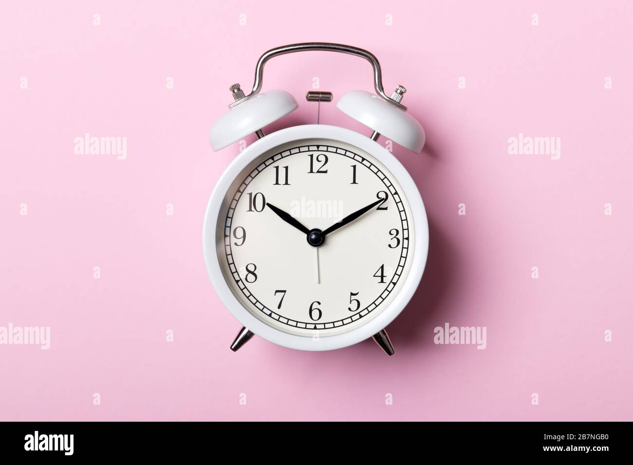 Weißer Vintage-Wecker auf pinkfarbenem Hintergrund. Zeitkonzept Stockfoto Weißer Vintage-Wecker auf pinkfarbenem Hintergrund. Zeitkonzept Stockfoto