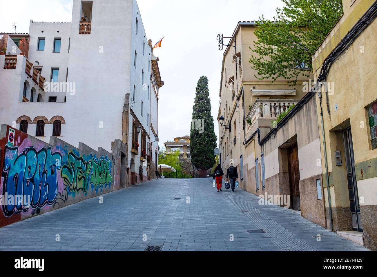 Ein Paar bummeln sich am Tag bef durch die normalerweise belebten Straßen von Sant Cugat del Valles, einer Stadt mit etwa 90.000 Menschen außerhalb Barcelonas Stockfoto