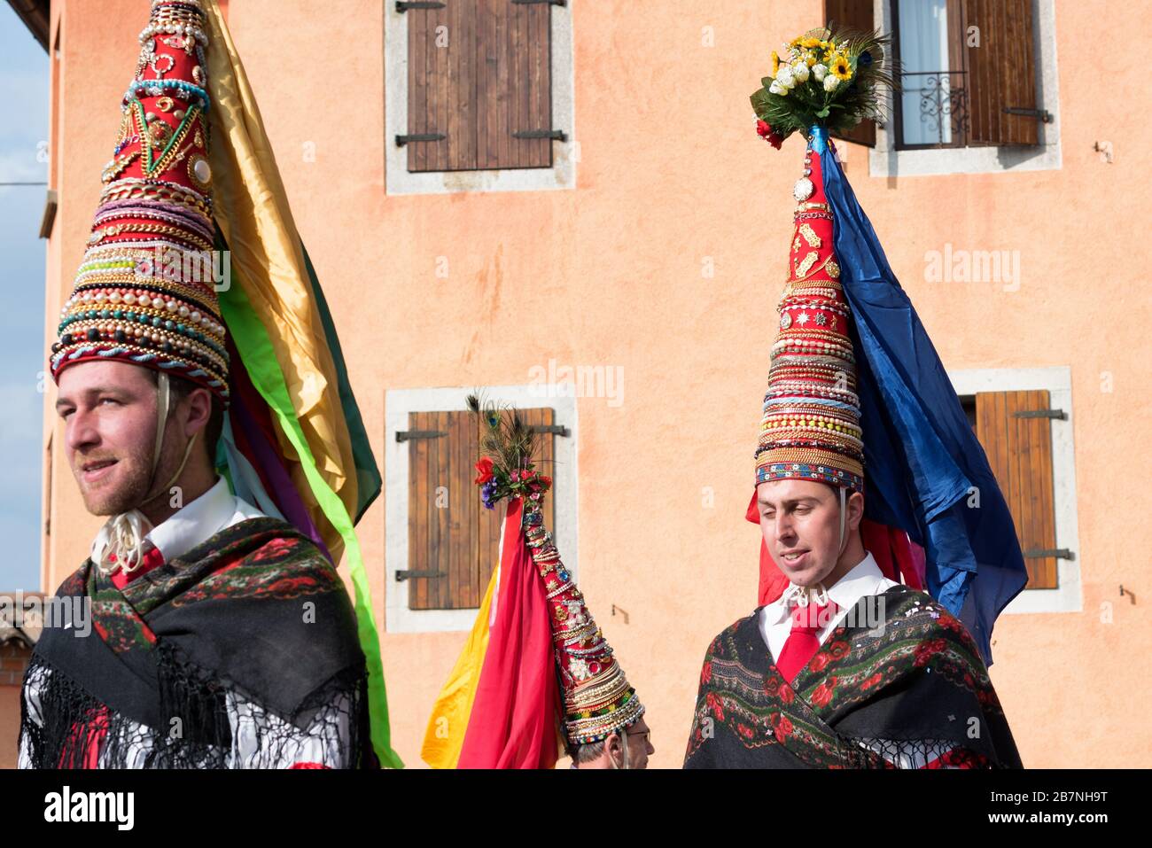 Männer in Karnevalskostüm während des Karnevalsumzugs Pust. Romeno Folkgruppe aus Trient. Mehrfarbig dekorierte Kegelhüte. Italienische Tradition. Italien Stockfoto
