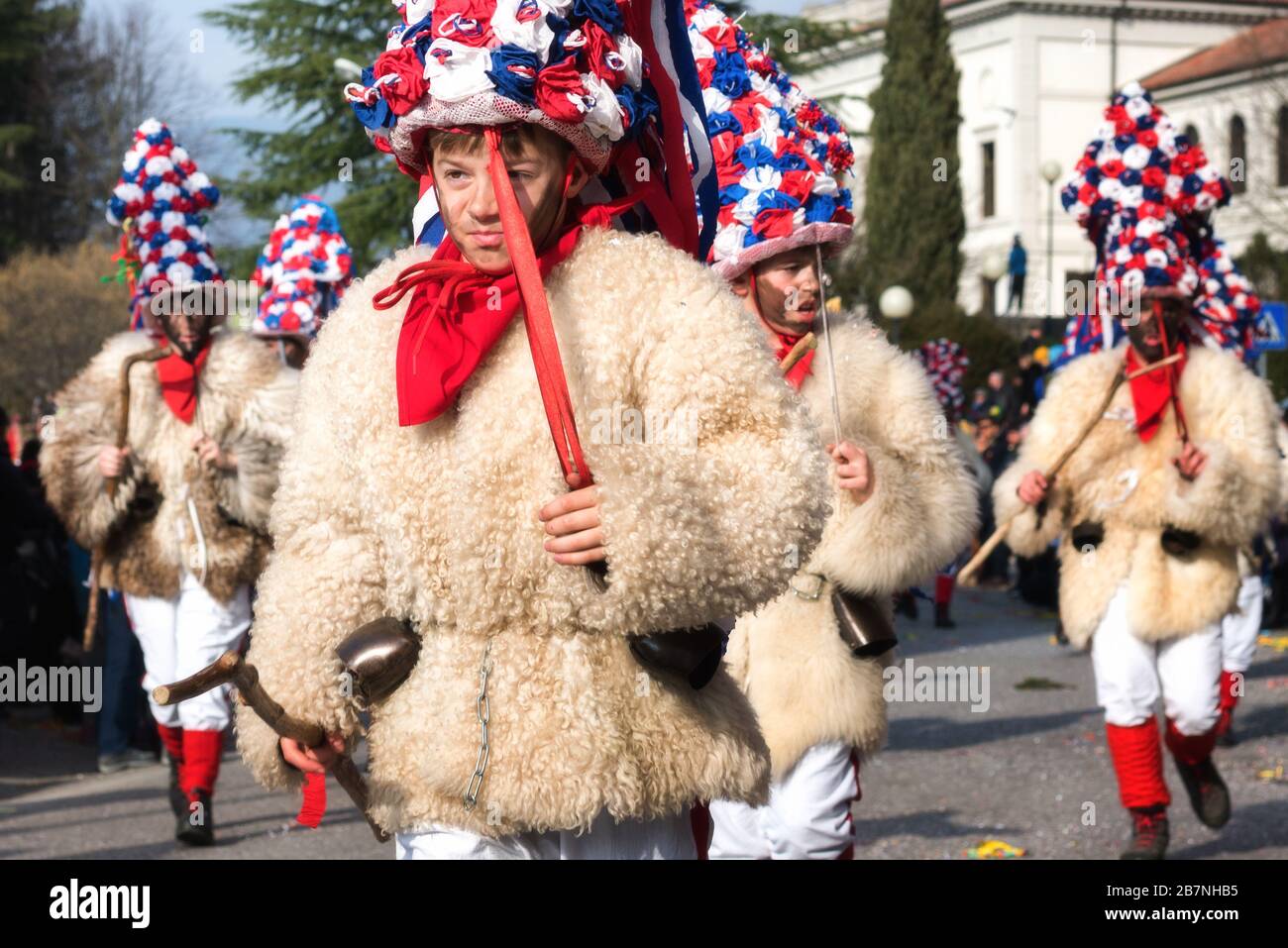 Junge Jungs in Zgoncar-Kostüm beim Karnevalsumzug Pust. Skoromati-Gruppe aus Castelnuovo d'Istrien. Heidnisches Traditionskonzept. Stockfoto