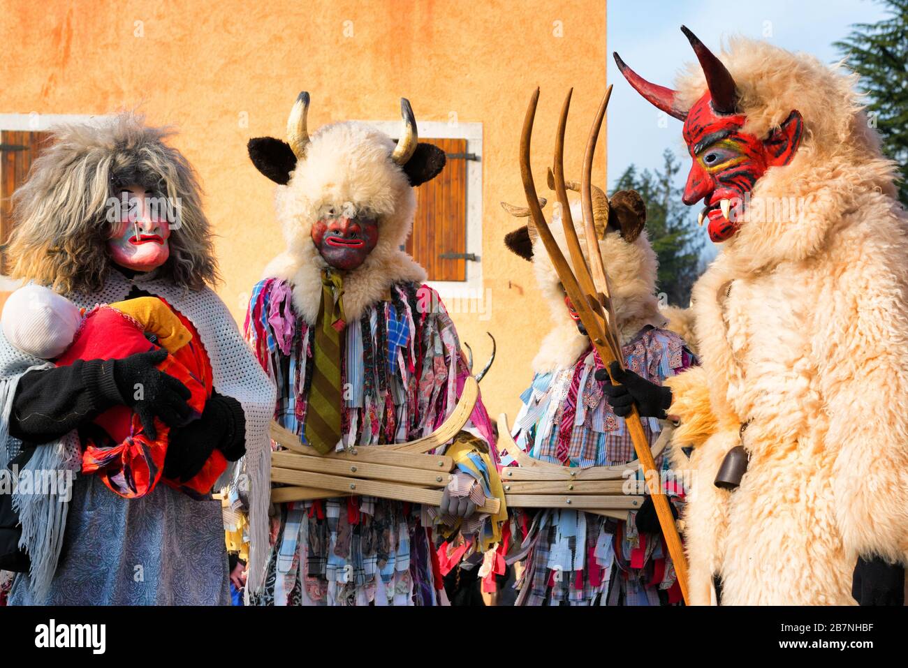 Nicht identifizierte Menschen, die heidnische Kostüme und Masken beim Karnevalszug Pust tragen. San Pietro al Natisone, Italien. Dämonen, die auf der Straße spazieren. Stockfoto