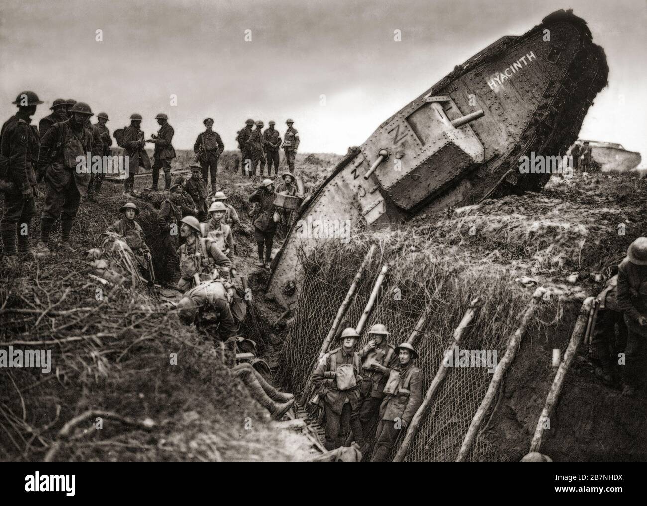 Soldaten des Leicestershire-Regiments versammeln sich um einen britischen Panzer, der in überrannten deutschen Schützengräben festsaß, während der dritten Schlacht von Ypern alias der Schlacht von Passchendaele, einer Kampagne des ersten Weltkriegs, Das fand von Juli bis November 1917 an der Westfront zur Kontrolle der Grate südlich und östlich der belgischen Stadt Ypern in Westflandern statt. Stockfoto