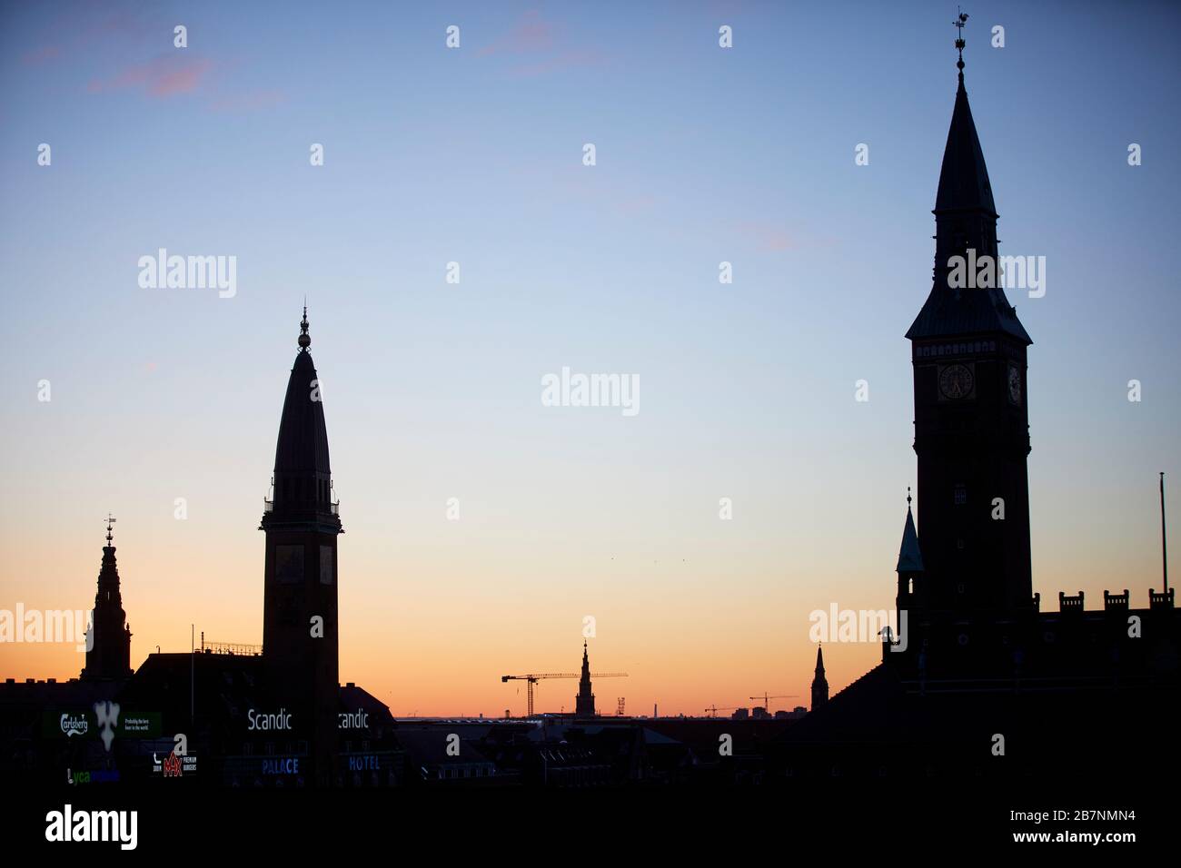 Kopenhagen, die Hauptstadt Dänemarks, der Uhrturm des Scandic Palace Hotels und der City-Hall-Uhrturm wurden bei Sonnenaufgang silhouettiert Stockfoto