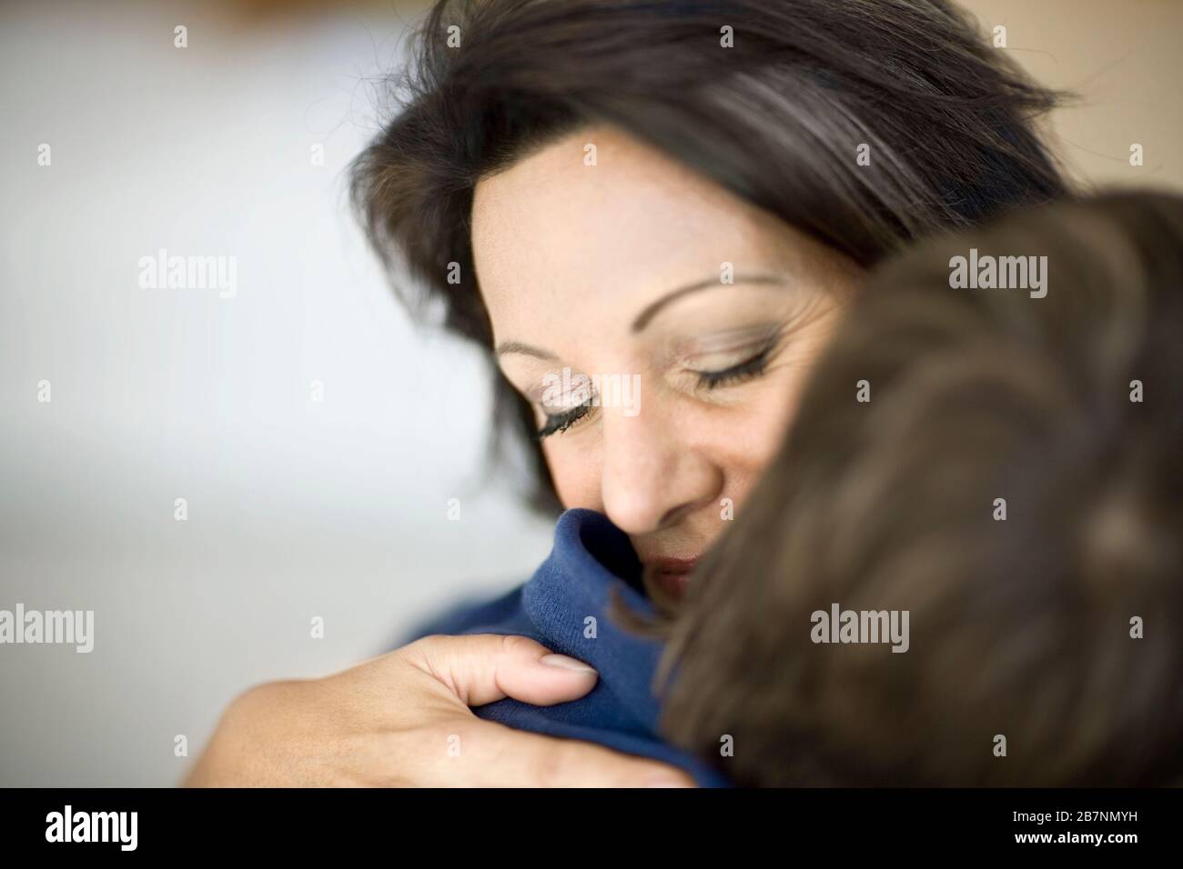 Mutter umarmt ihren jungen Sohn. Stockfoto