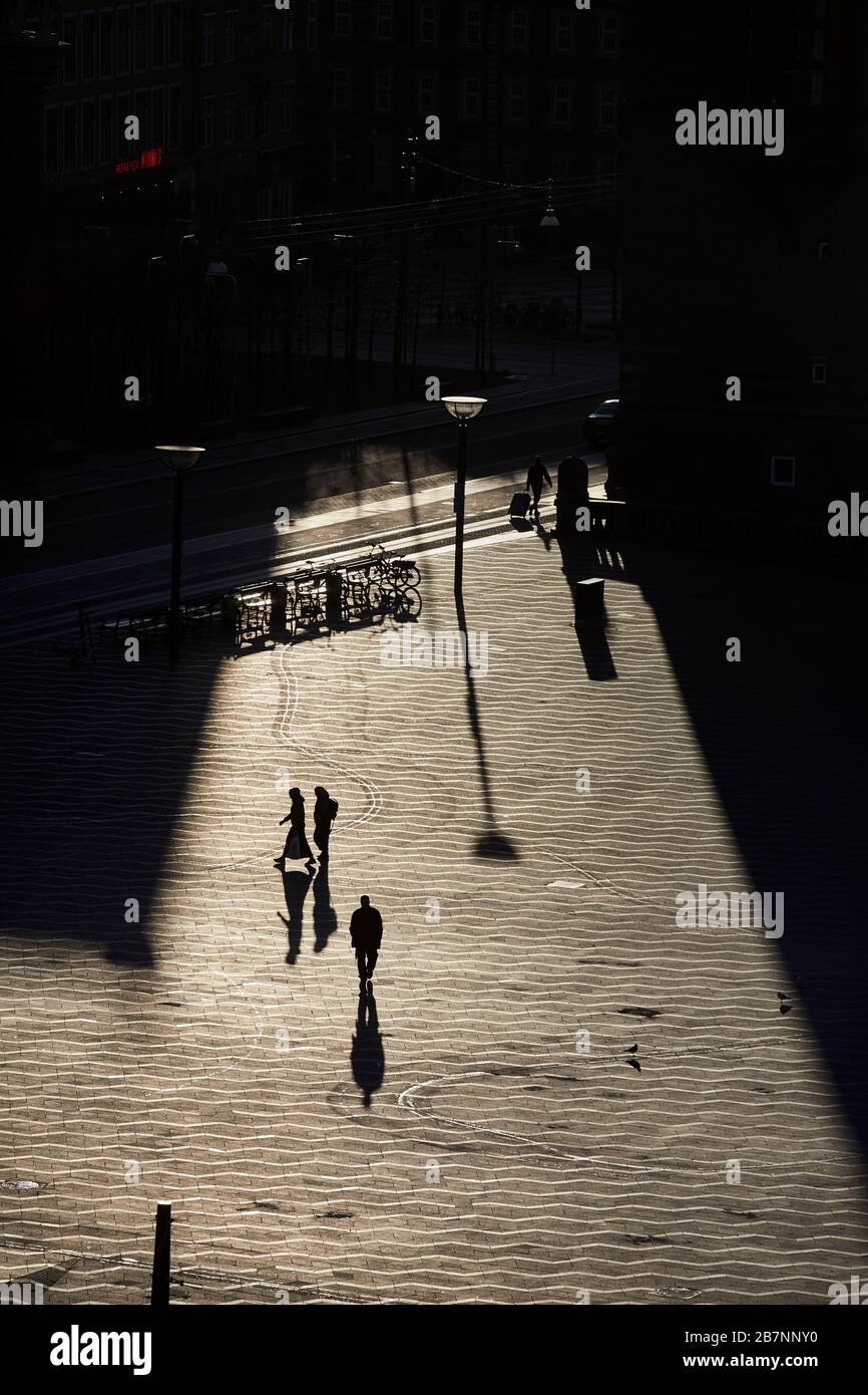 Kopenhagen, Dänemarks Hauptstadt, Silhouetten langer Schatten über dem Rathausplatz bei Sonnenaufgang Stockfoto