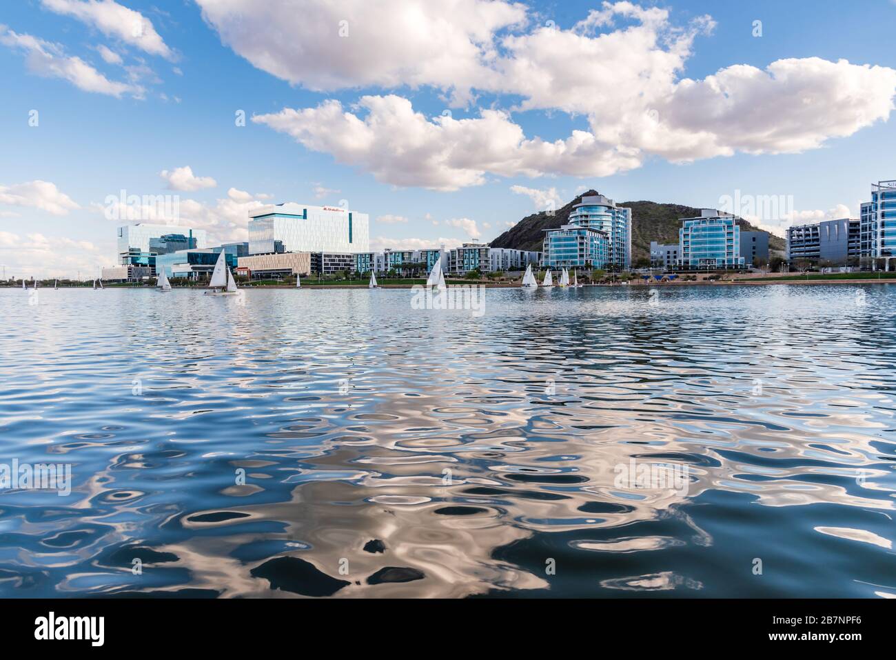 Tempe Town Lake South Shore luxuriöse Eigentumswohnungen am Wasser und gläsernen Bürogebäuden, blauer Himmel und Wasser und ein Segelboot, das von einer Regatta kommt. Stockfoto