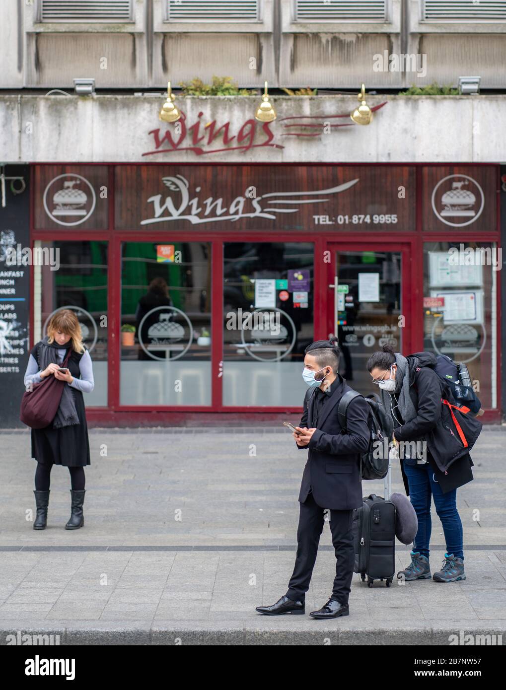 Dublin, Irland. März 2020. Dublins St. Patricks's Festival/Parade. Die O'Connell Street, das Zentrum der Stadt Dublin, ist normalerweise voller Besucher für eine der größten kulturellen Feiern der Welt, die aufgrund des Corona Virus/Covid 19 fast menschenleer ist. Abgebildet sind Personen, die Schutzmasken tragen, während ein anderer "soziale Distanz" beibehält. Kredit: Barry Cronin/Alamy Live News Stockfoto