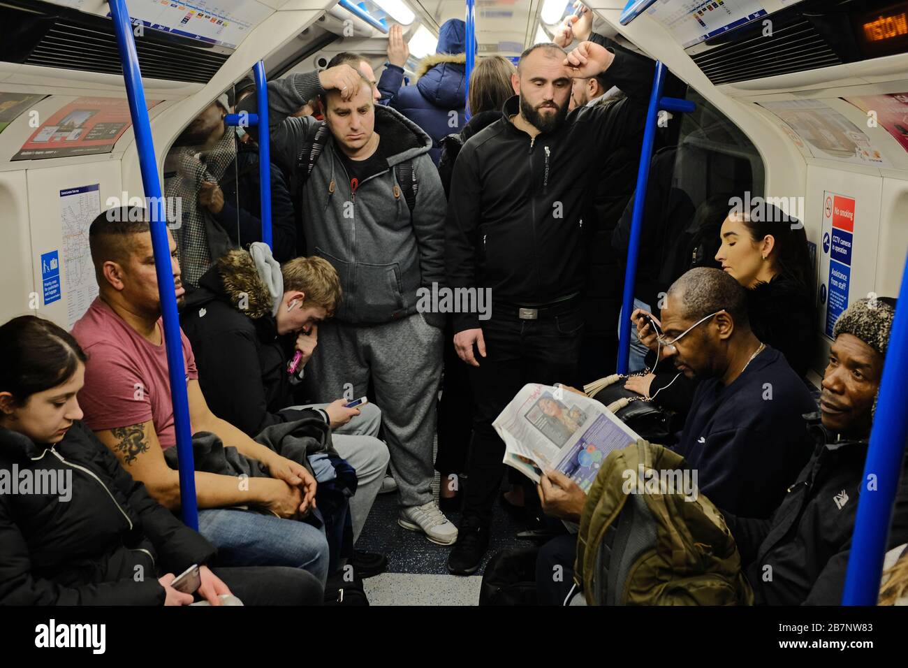 Die Menschen, die in London zur Hauptverkehrszeit mit einer U-Bahn unterwegs sind, obwohl Premierminister Boris Johnson die Menschen auffordert, sich von Kneipen, Clubs und Theatern fernzuhalten, möglichst von zu Hause aus zu arbeiten und alle nicht notwendigen Kontakte zu vermeiden und zu reisen, um die Auswirkungen der Coronavirus-Pandemie zu verringern. Stockfoto