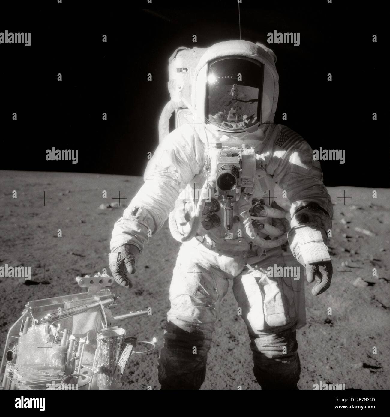 Apollo 12 - NASA, 1969. Astronaut Alan L. Bean, Pilot des Lunar Module, pausiert während des Apollo 12-Raumflugs auf der Oberfläche des Mondes in der Nähe eines Werkzeugträgers. Commander Charles Conrad, Jr., der das Schwarzweißfoto aufgenommen hat, spiegelt sich in Beans Helmvisier, 1969, wider. Stockfoto