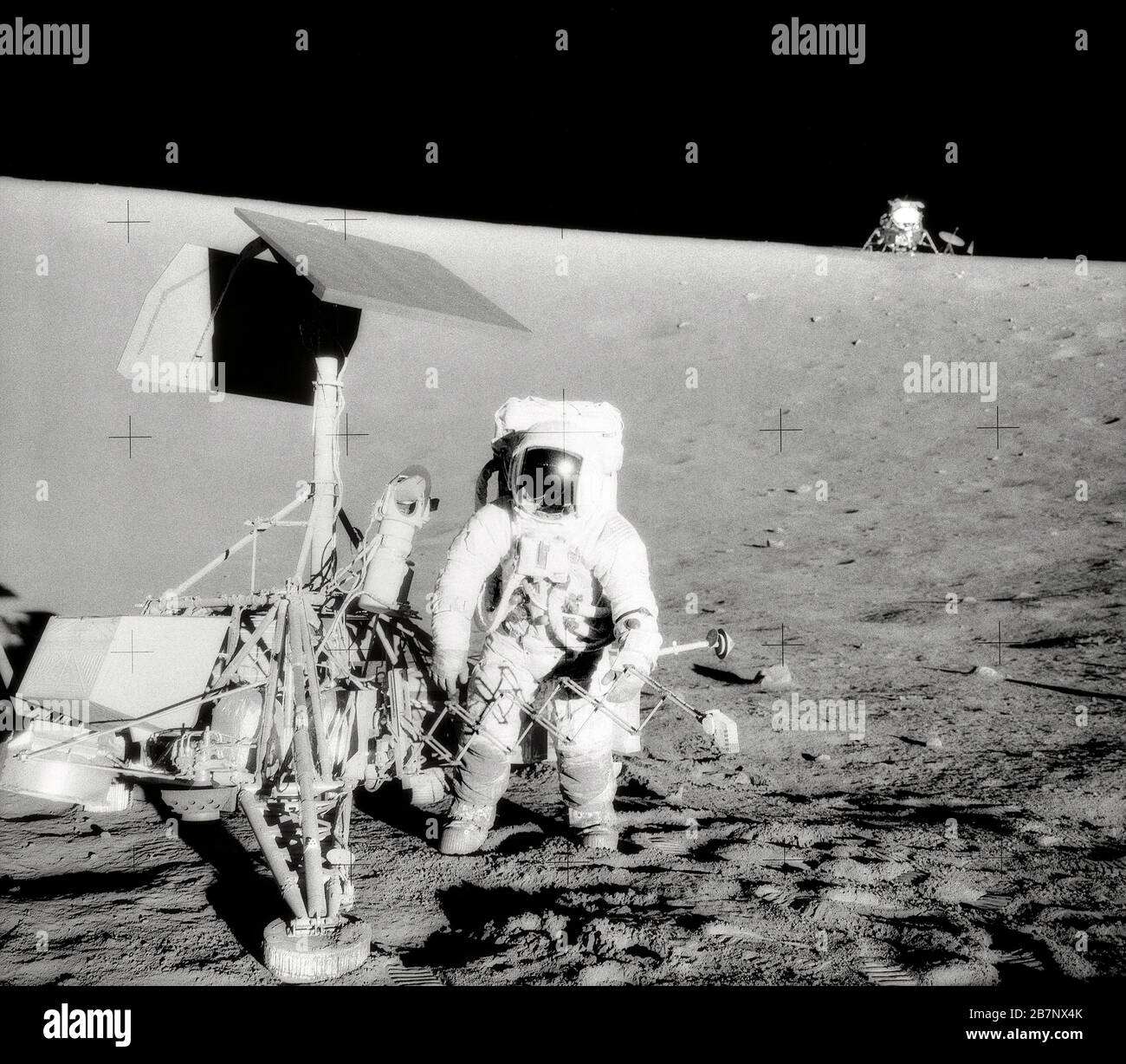 Apollo 12 - NASA, 1969. Charles Conrad Jr., Apollo 12 Commander, untersucht die unbemannte Raumsonde Surveyor III während der zweiten Extravehikelaktivität (EVA-2). Das Lunar Module (LM) "Intrepid" befindet sich im rechten Hintergrund. Dieses Bild wurde von dem Astronauten Alan L. Bean, Lunar Module Pilot, aufgenommen. Die "Intrepid" landete auf dem Ozean der Stürme des Mondes nur 600 Fuß von Surveyor III. Entfernt Stockfoto