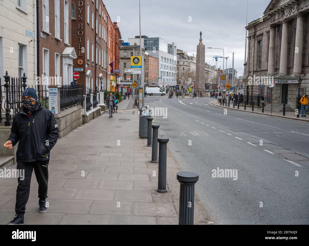 Dublin, Irland. März 2020. März 2020. Dublin's St. Patricks's Festival/Parade. Die O'Connell Street, das Zentrum der Stadt Dublin, ist normalerweise voller Besucher für eine der größten kulturellen Feiern der Welt, die aufgrund des Corona Virus/Covid 19 fast menschenleer ist. Abgebildet ist ein Mann, dessen Gesicht mit einem Schal bedeckt ist. Kredit: Barry Cronin/Alamy Live News Stockfoto