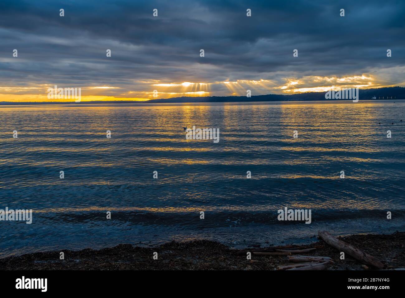 Lichtstrahlen durch dunkle Wolken über dem Puget Sound hinab. Stockfoto