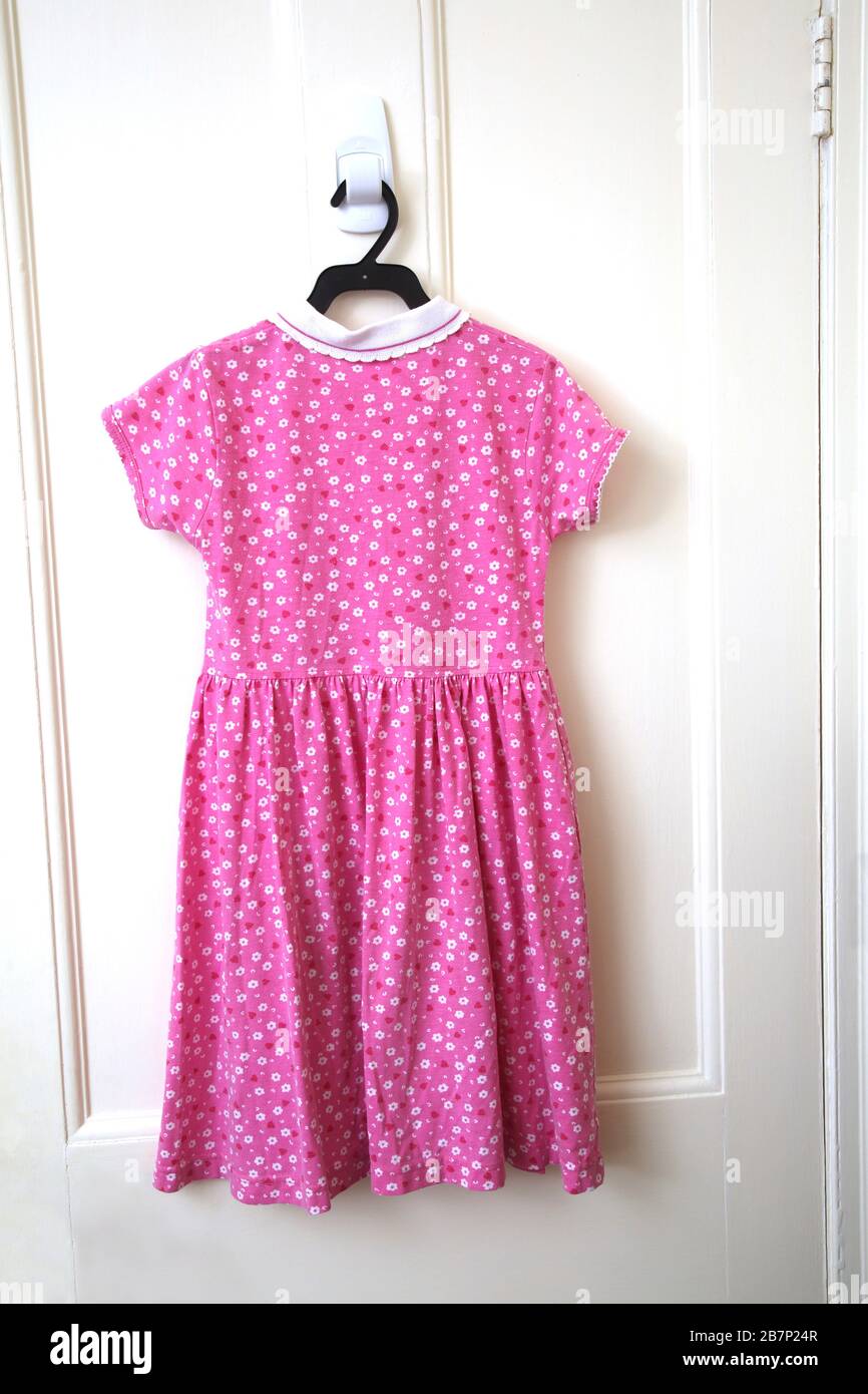 T-Shirt-Kleid mit pinkfarbenem und weißem Blumenmuster für Kinder Stockfoto