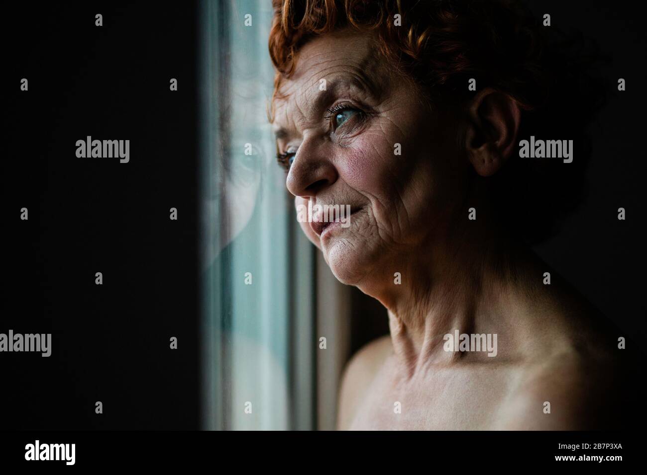 Frau am Fenster, die über das Leben nachdenkt Stockfoto