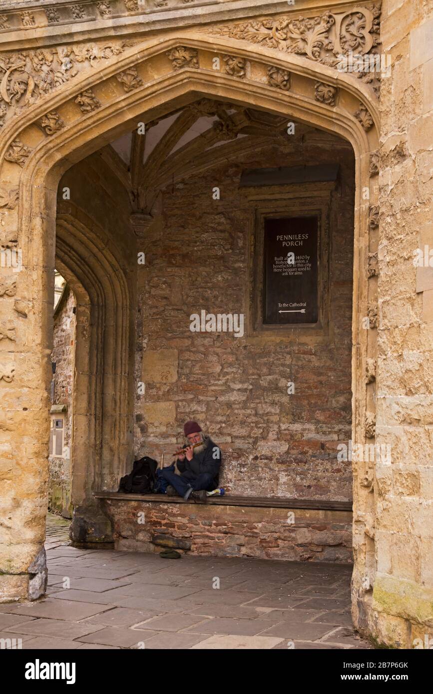 Ein Straßenmusiker spielt in mittellosen Veranda, die das Tor zwischen dem Marktplatz und der Kathedrale in Wells, Somerset, England, Großbritannien ist Stockfoto