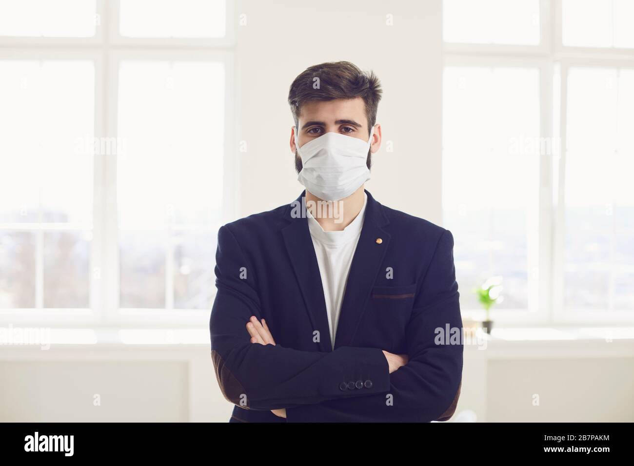 Infektionsgefahr der Virus-Coronavirus-Infektion. Geschäftsmann in medizinischer Maske im Büro Stockfoto