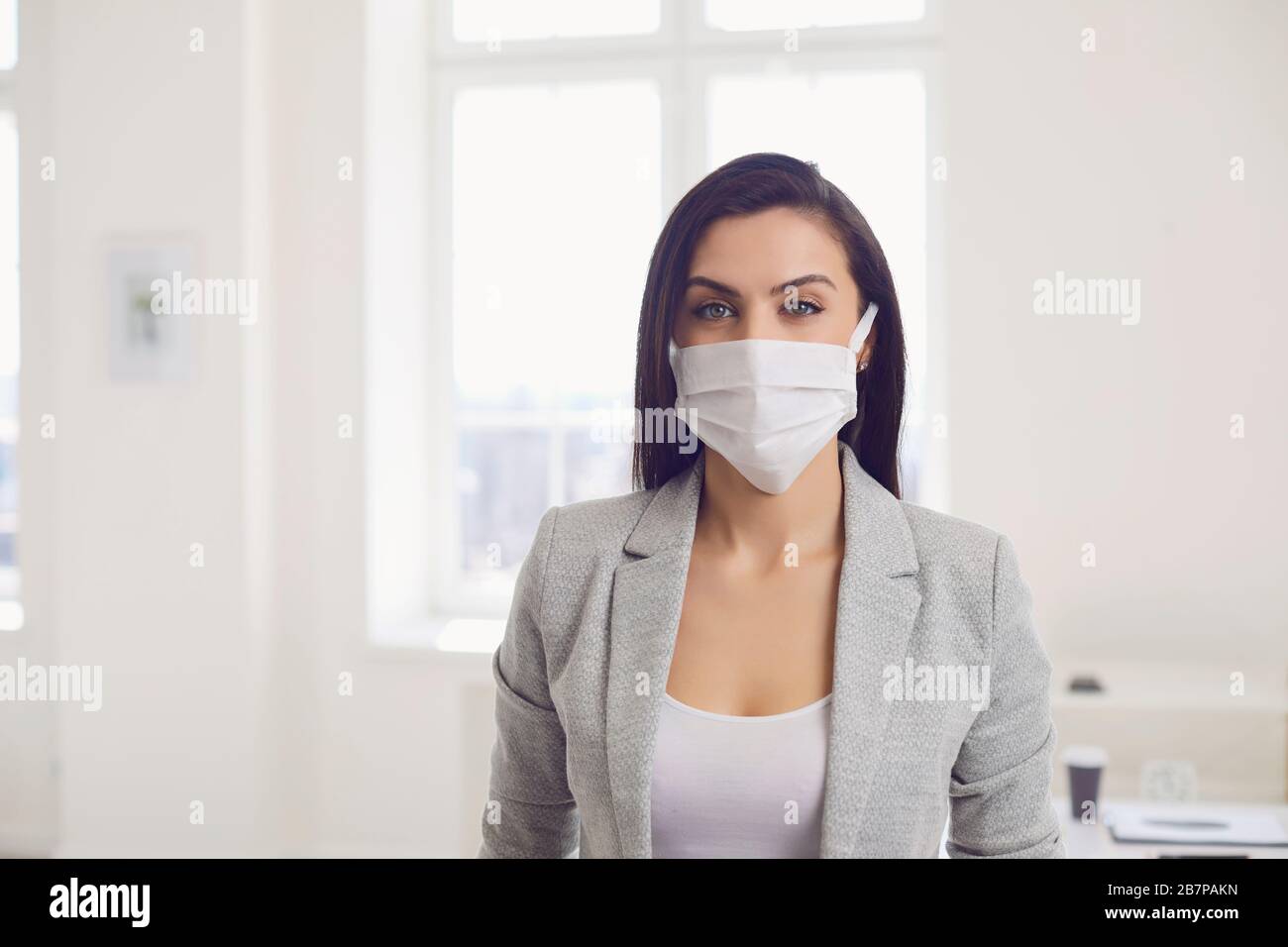 Infektionsgefahr der Virus-Coronavirus-Infektion. Geschäftsfrau in medizinischer Maske im Büro Stockfoto