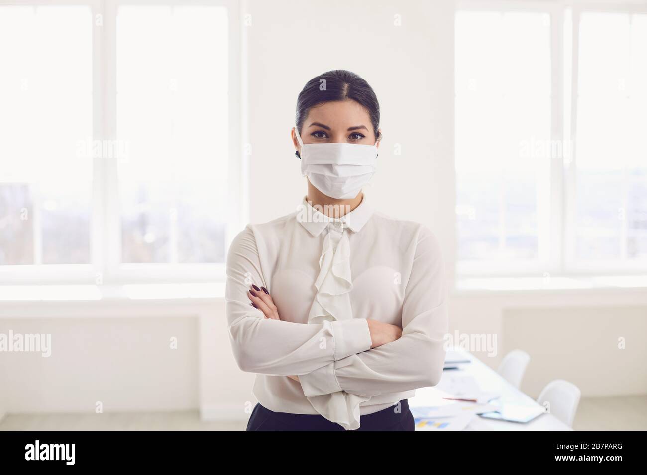 Infektionsgefahr der Virus-Coronavirus-Infektion. Geschäftsfrau in medizinischer Maske im Büro Stockfoto