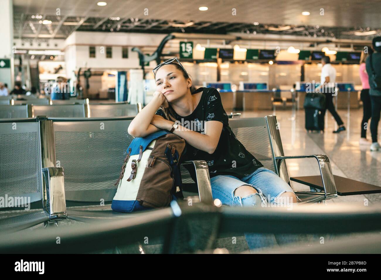 Verärgert oder gelangweilt Mädchen Touristen oder Studenten am Flughafen. Ihr Flug war verspätet oder sie war müde. Stockfoto