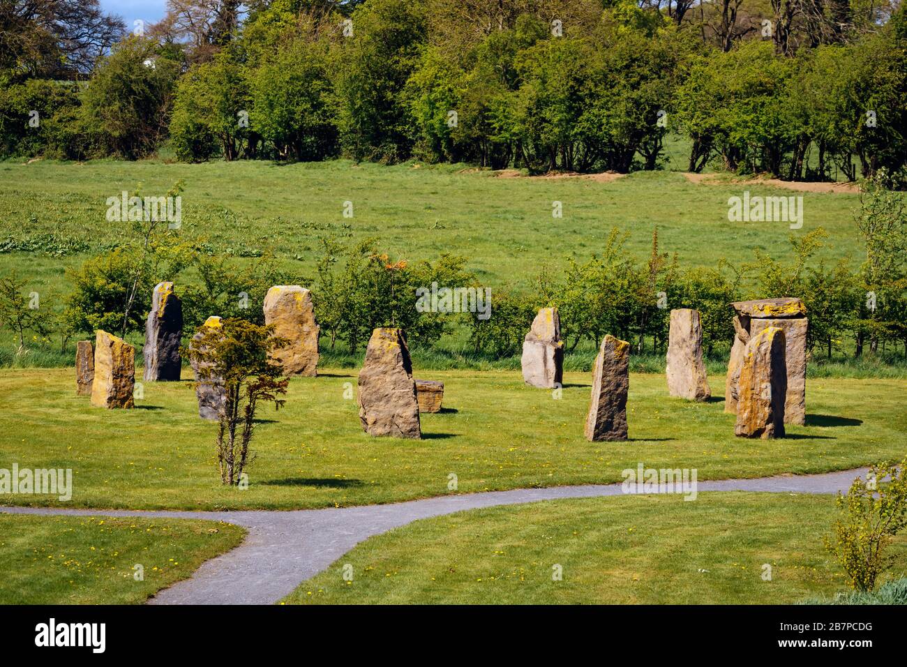 Uralte Megalithsteinformation oder Denkmal auf Grünfeld mit Wald im Hintergrund Stockfoto