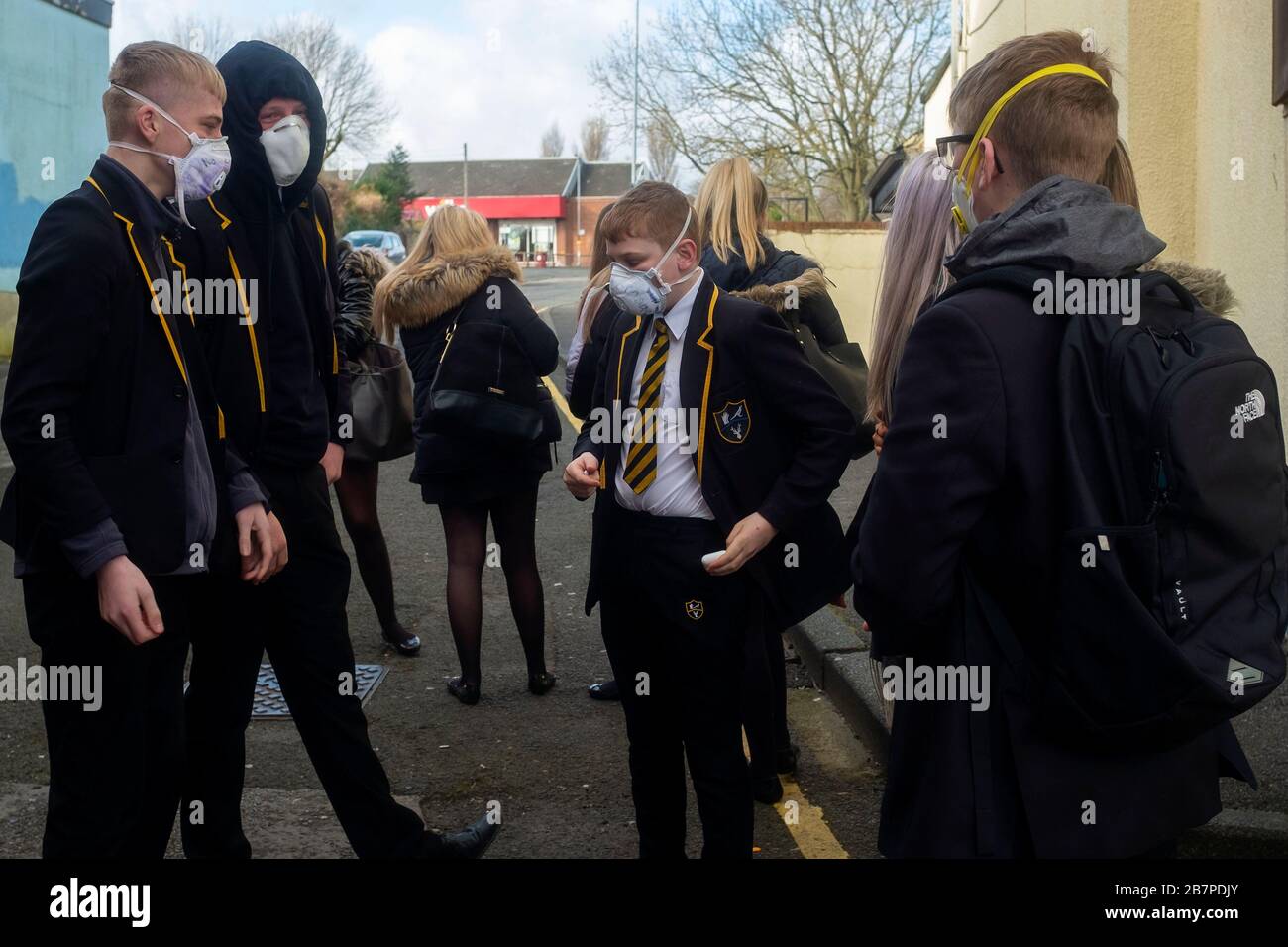 Schulkinder, die Gesichtsmasken tragen, machen sich am 17. März 2020 auf den Weg zur Park View School, Chester le Street, Durham, Großbritannien. Stockfoto