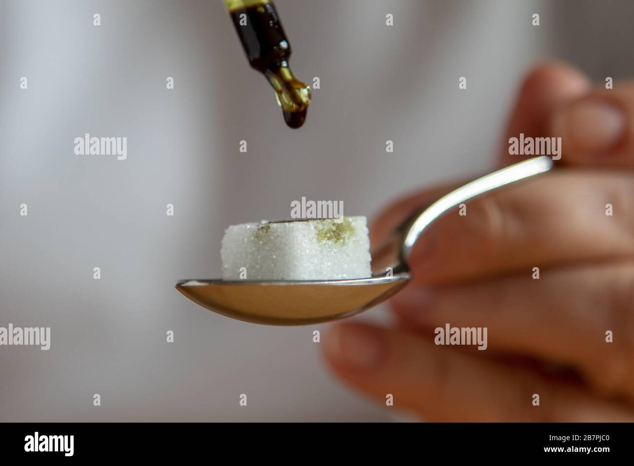 Zuckerwürfel auf einem Teelöffel, Medikamente werden Tropfen für Tropfen  mit einer Pipette hinzugefügt Stockfotografie - Alamy