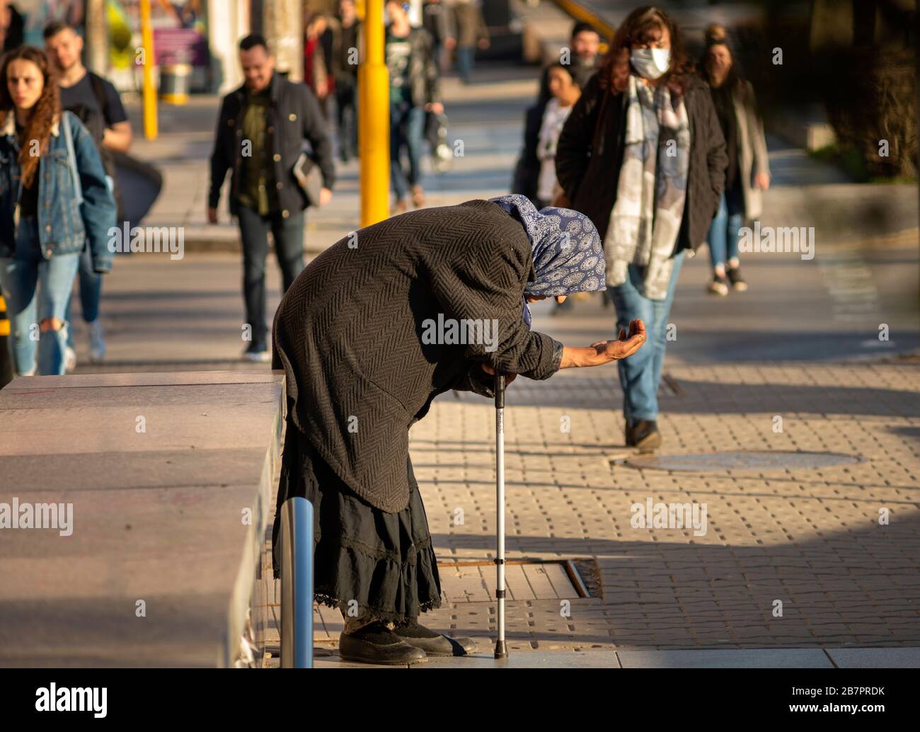 Alte Bettler-Seniorin in schwarzer Kleidung und mit einem Stock bettelt seit 2020 auf den Straßen in Sofia, Bulgarien, um Geld Stockfoto