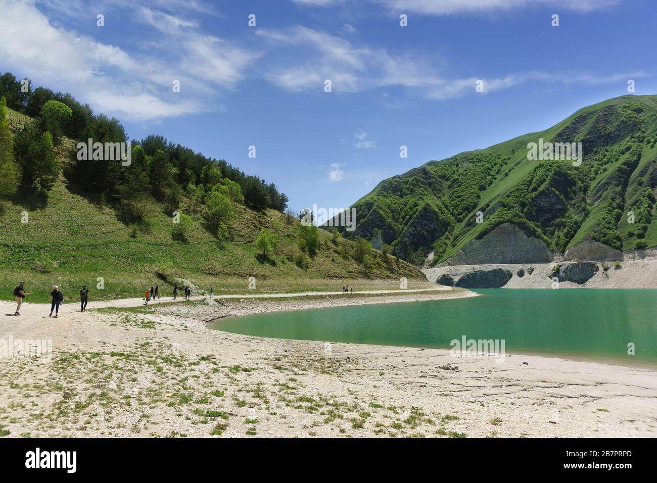 Touristen am Ufer des Bergsees Kezenoi am Botlikh-Distrikt der Republik Dagestan. Saftige Grüns im Frühsommer. Russland, Nord-Cau Stockfoto