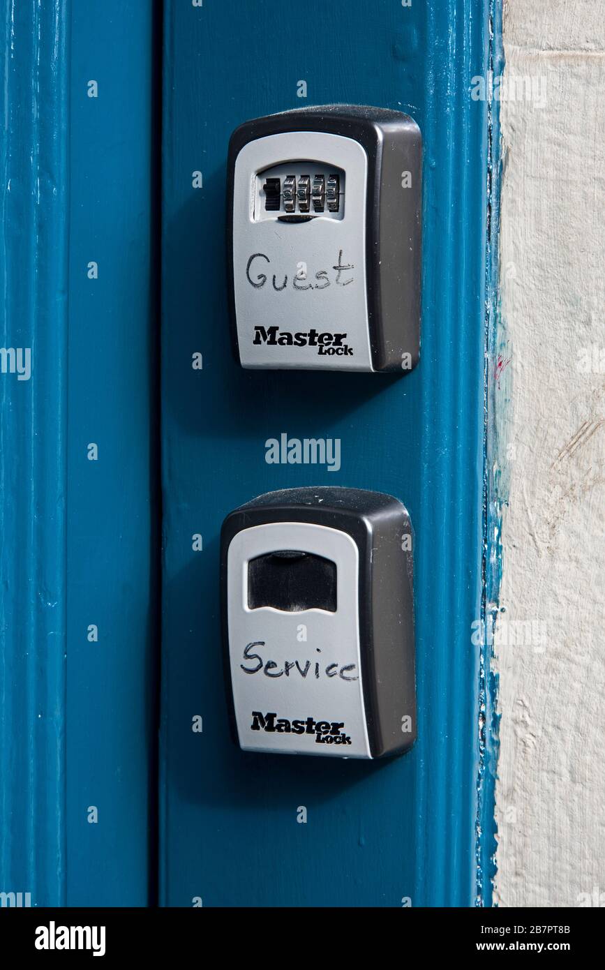 Schlüsselsafes für Airbnb oder kurzfristig lassen sich an der Tür zu einem Mietservice in Bruntsfield, Edinburgh, Schottland, Großbritannien mit "Gast" und "Service" beschriften. Stockfoto