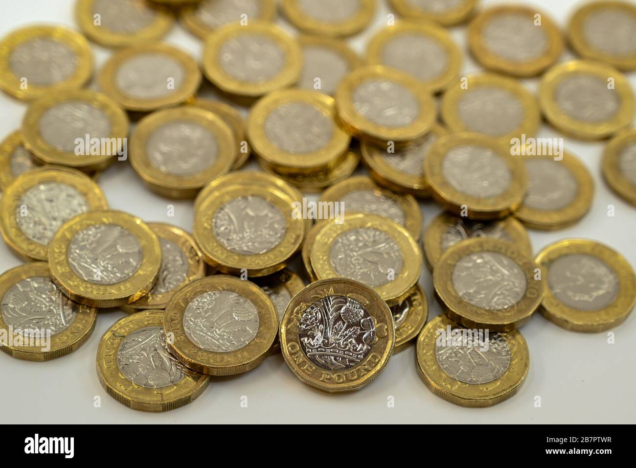 LONDON, Großbritannien - JANUAR 2020: Nahaufnahme der britischen Währung Great British Pound GBP - eine Pound-Münze, die sich auf andere Münzen stützt, verschwommen im Hintergrund Stockfoto