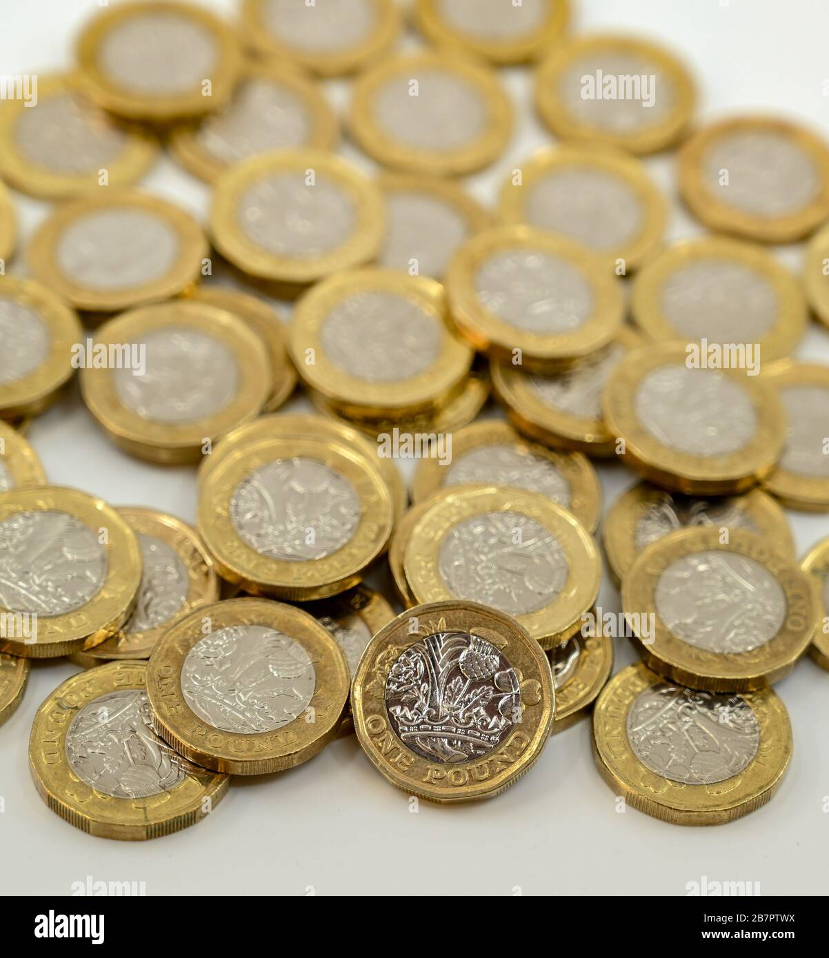 LONDON, Großbritannien - JANUAR 2020: Nahaufnahme der britischen Währung Great British Pound GBP - eine Pound-Münze, die sich auf andere Münzen stützt, verschwommen im Hintergrund Stockfoto