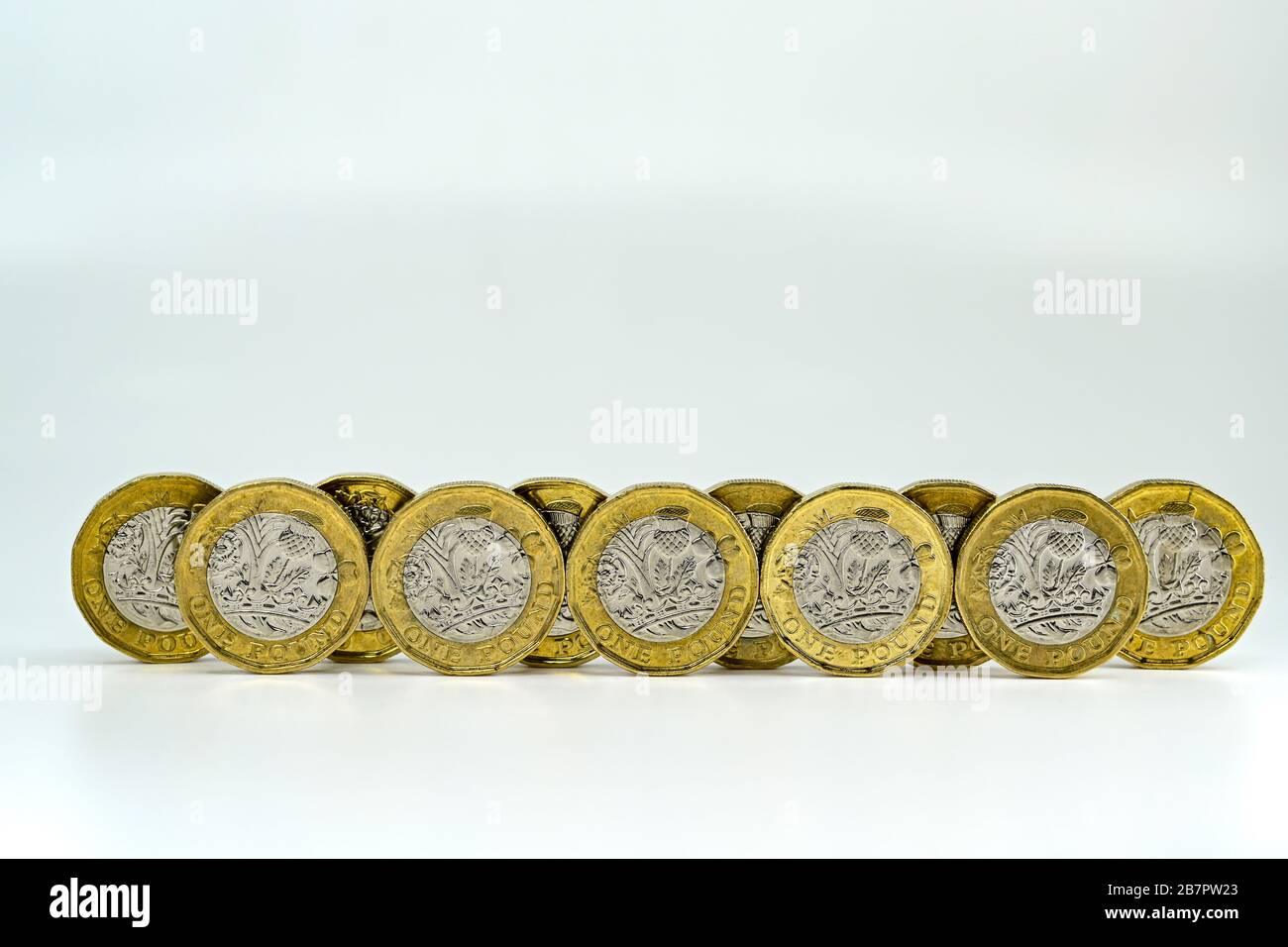 CARDIFF, WALES - JANUAR 2020: Nahaufnahme der britischen Währung GBP - One Pound Coins auf einem einfarbigen weißen Hintergrund Stockfoto