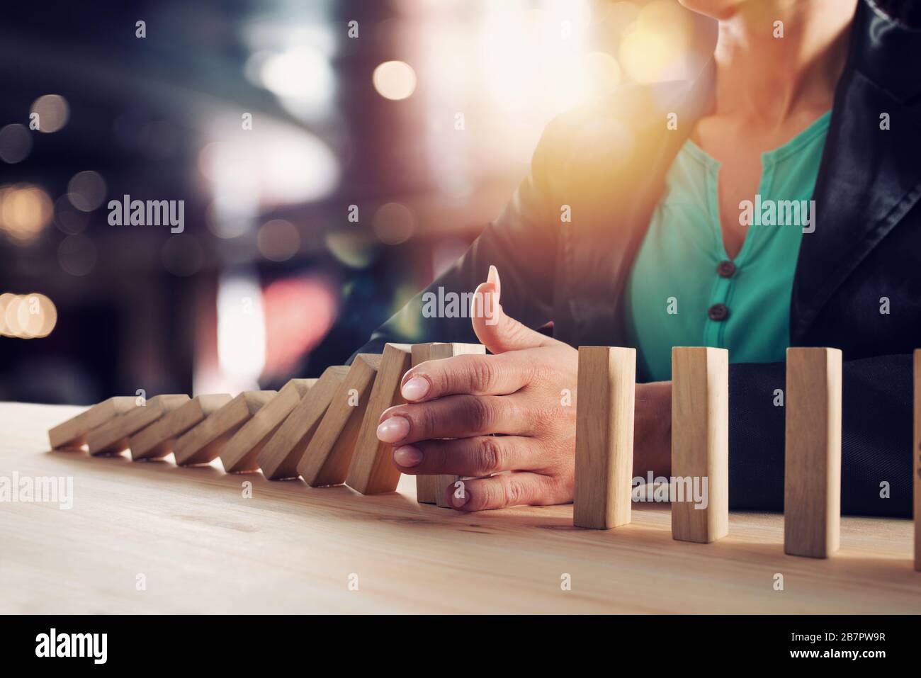 Geschäftsfrau hält eine Kette fallen wie Domino Spiel. Konzept zur Vermeidung der Krise und Ausfall im Geschäft. Stockfoto