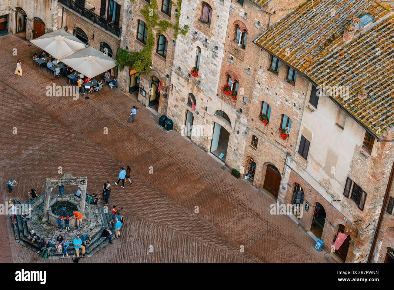 Blick auf die Piazza della Cisterna vom Gipfel des Torre Grossa in San Gimignano, Provinz Siena, Toskana, Italien, im Sommer. Stockfoto