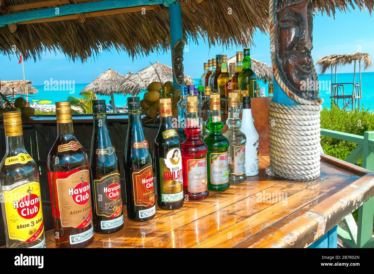 Flaschen Havanna Club Rum an der Bar mit Strand hinter Kuba Stockfoto