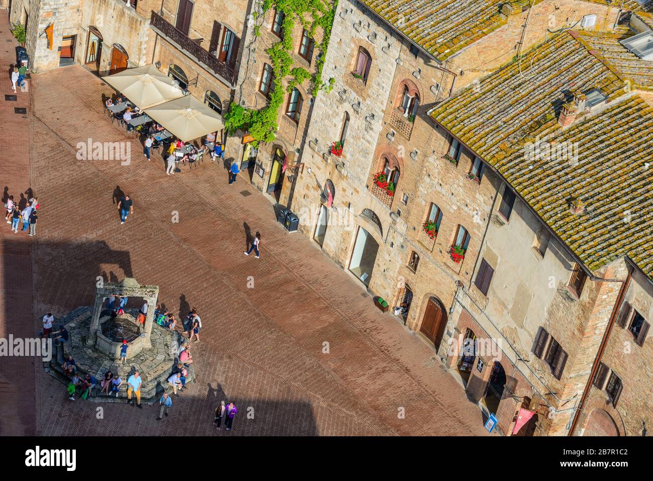 Blick auf die Piazza della Cisterna vom Gipfel des Torre Grossa in San Gimignano, Provinz Siena, Toskana, Italien, im Sommer. Stockfoto