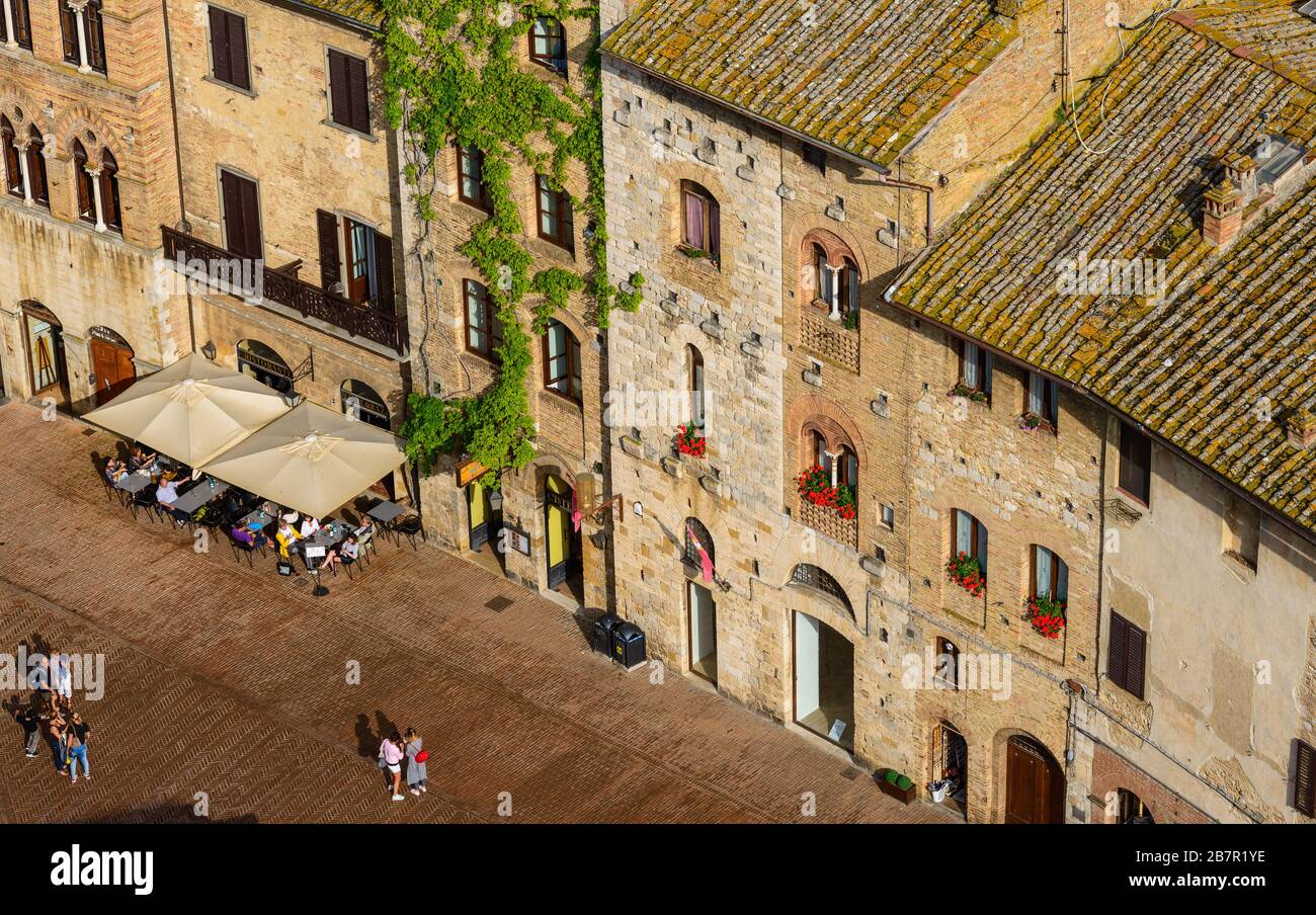 Blick auf die Piazza della Cisterna vom Gipfel des Torre Grossa in San Gimignano, Provinz Siena, Toskana, Italien, im Sommer. Stockfoto