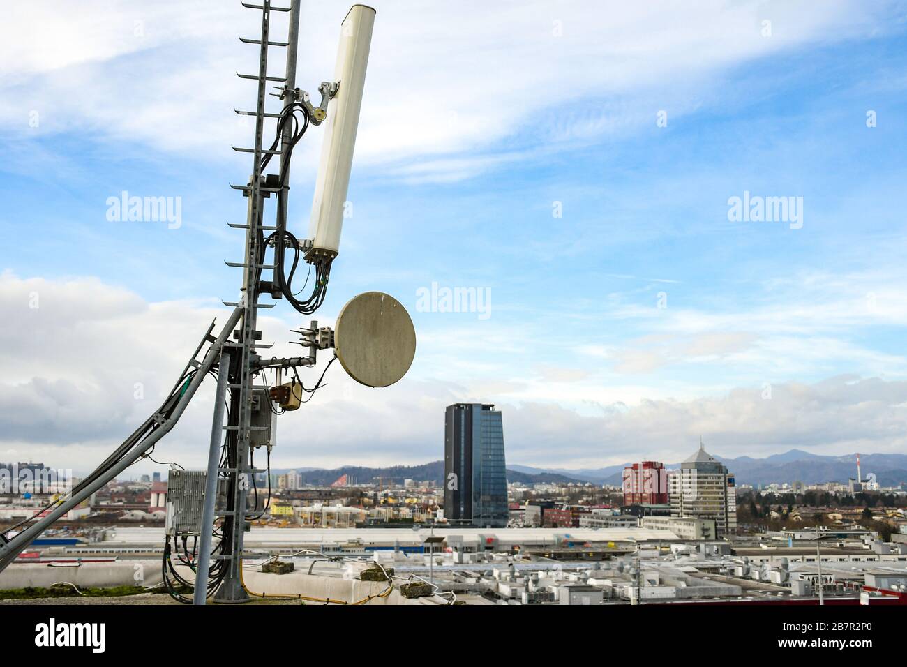 Mobilfunk-Telekommunikationsnetzantenne auf einem Metallpol für starke Signalwellen von der Dachspitze in der Großstadt Stockfoto