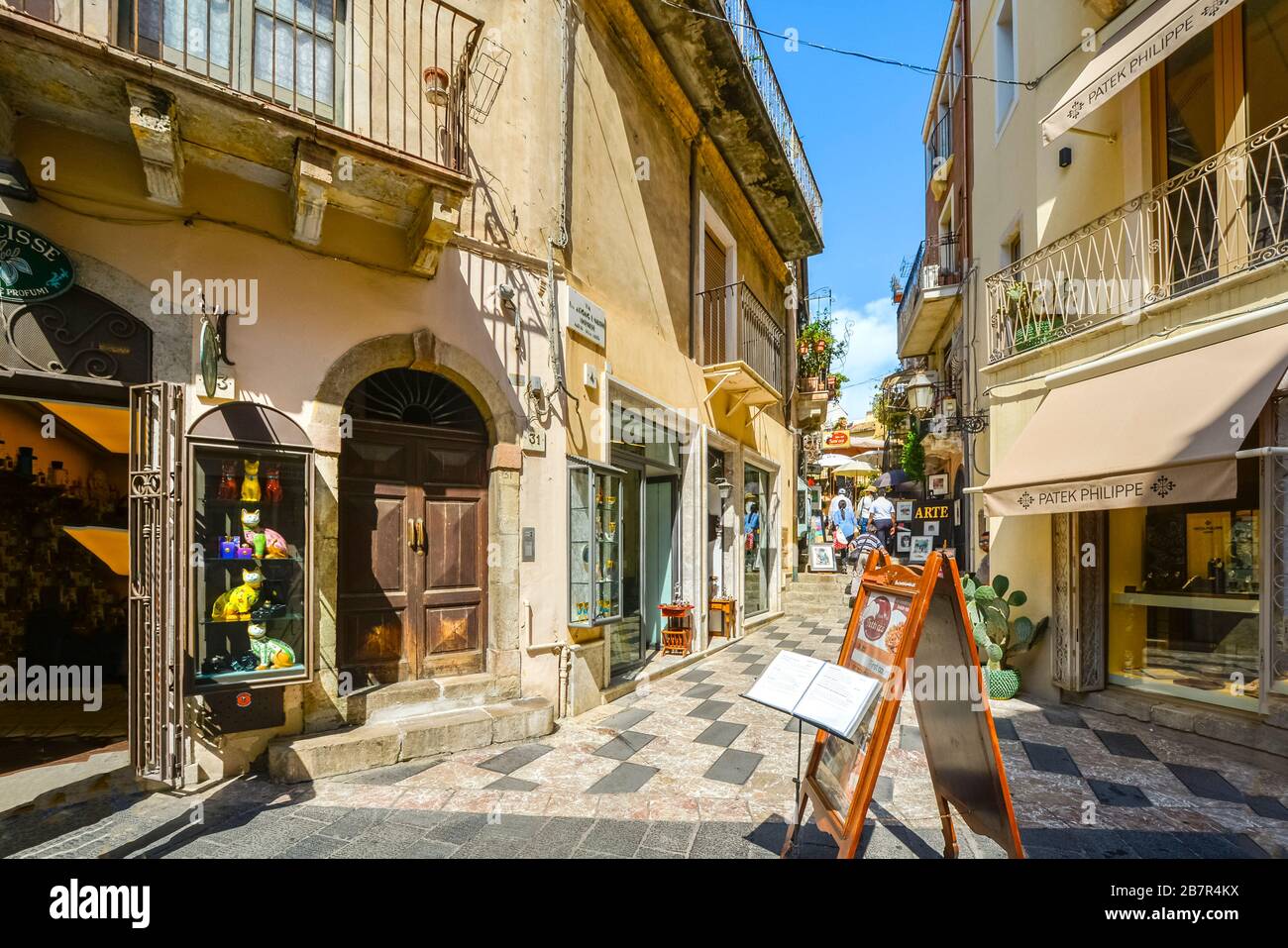 Eine bunte Straße mit Geschäften und Cafés in der Ferienstadt Taormina auf der Insel Sizilien. Stockfoto