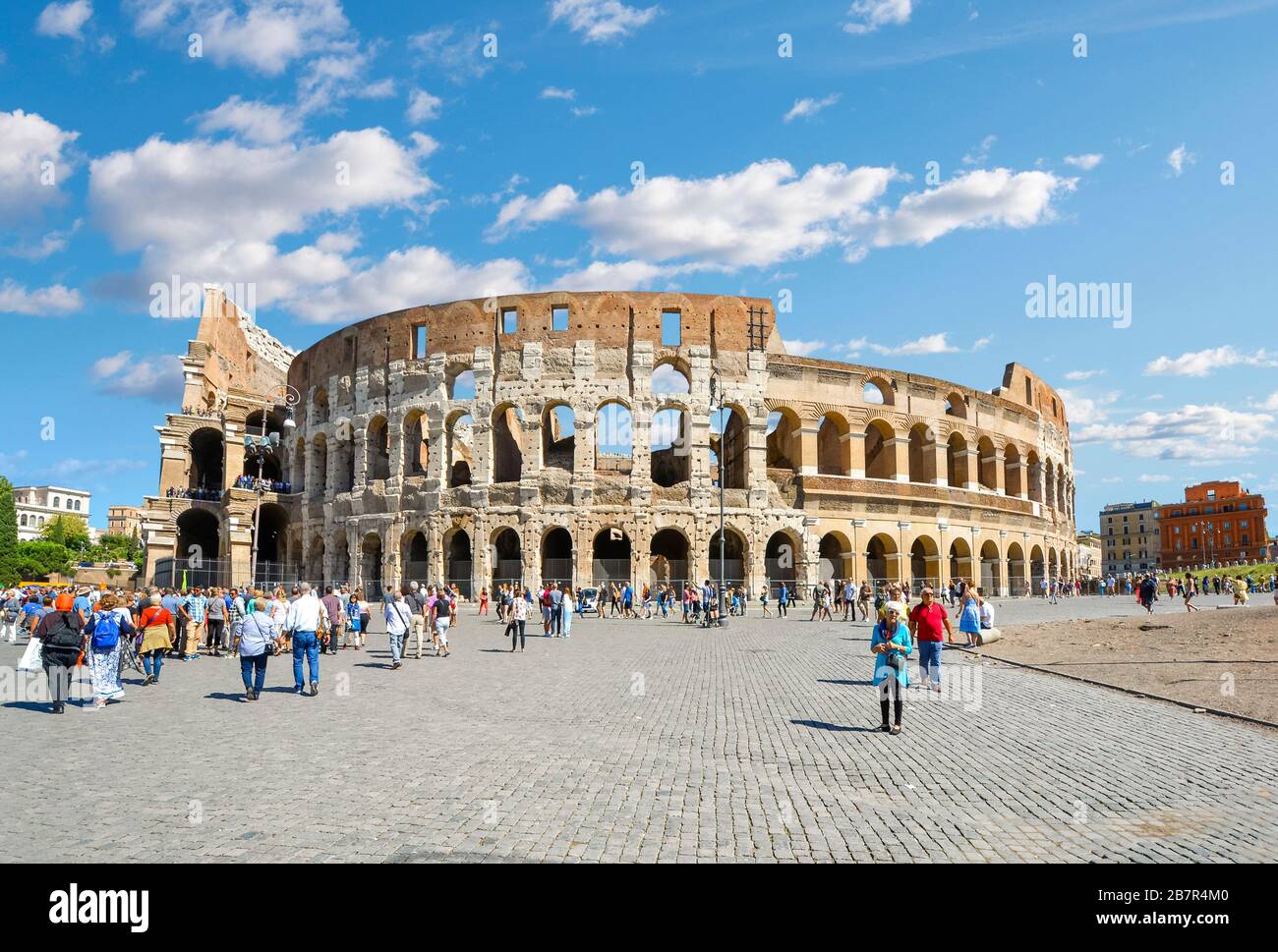An einem sonnigen Sommertag in Rom, Italien, wandern Touristen am alten römischen Kolosseum vorbei. Stockfoto