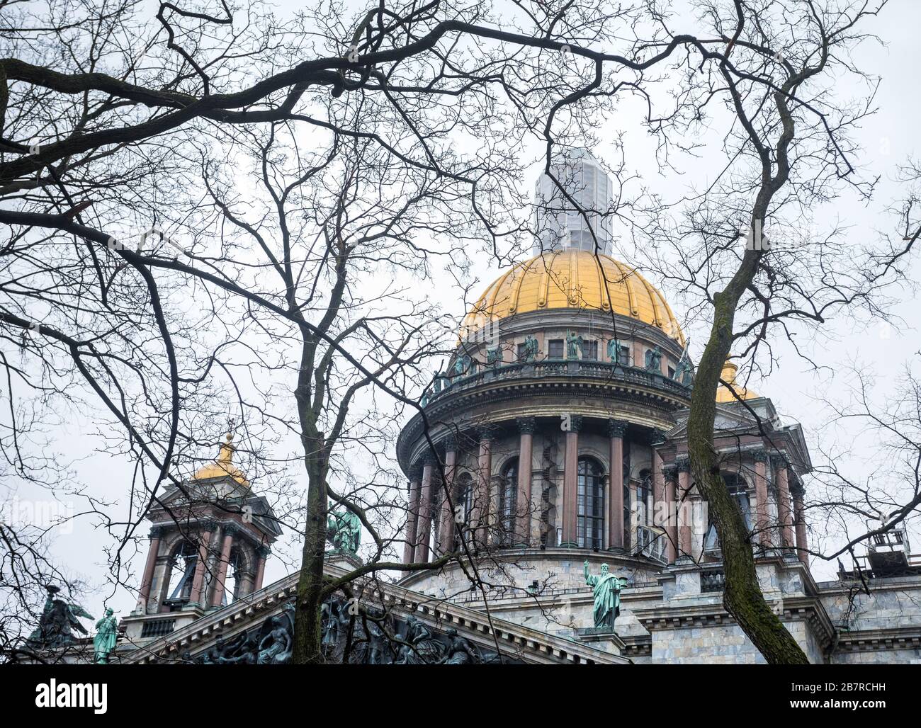 Berühmte Isaak Kathedrale und alten Eichen am dramatischen grauen Himmel in St. Petersburg, Russland Stockfoto