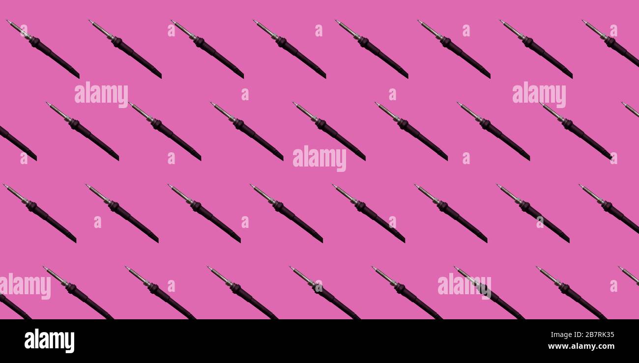 Viele Lötkolben blicken in die Ecke. Lötkolben sind auf einem rosafarbenen Hintergrund abgebildet. Stockfoto