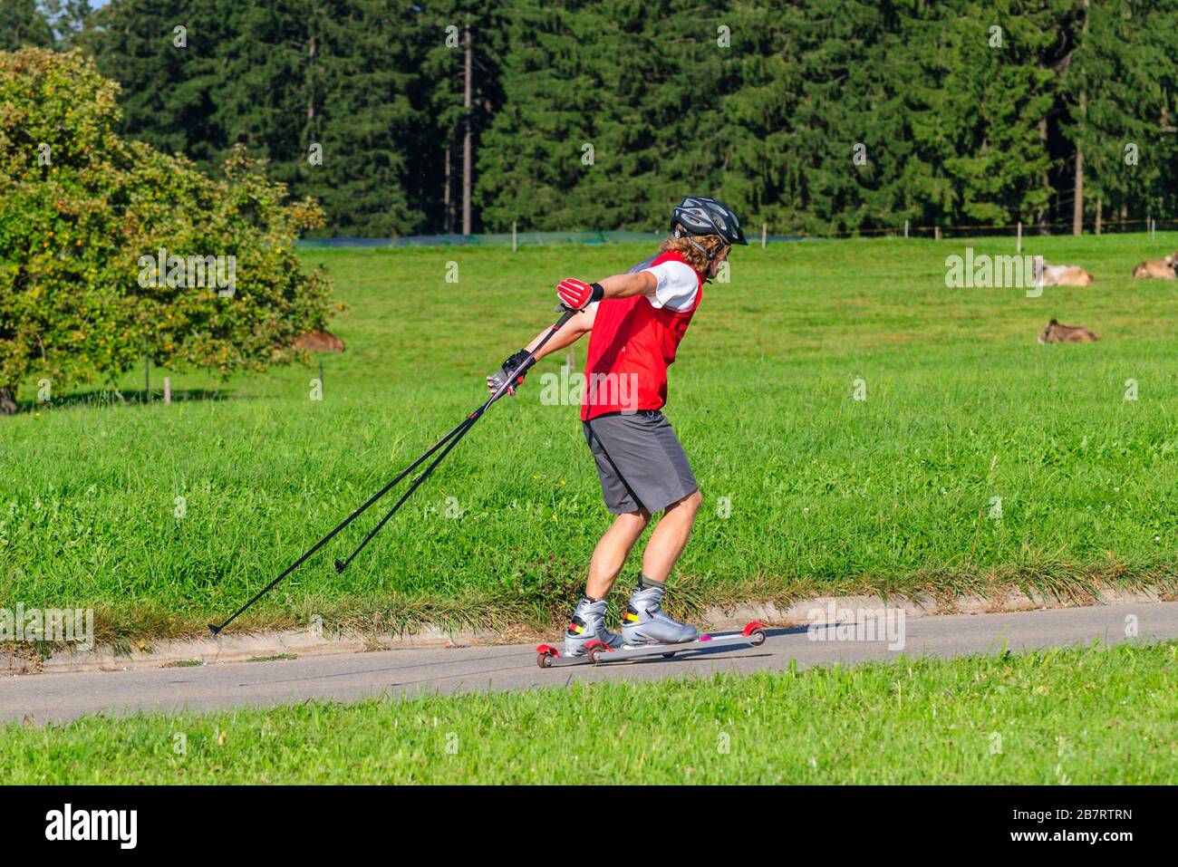 Junger und sportlicher Mann, der im Sommer eine anstrengende Ski-Roller-Sitzung macht Stockfoto